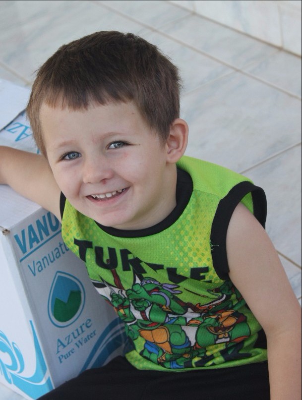 Elijah, age 4, sitting on our porch resting his arm on a cardboard box